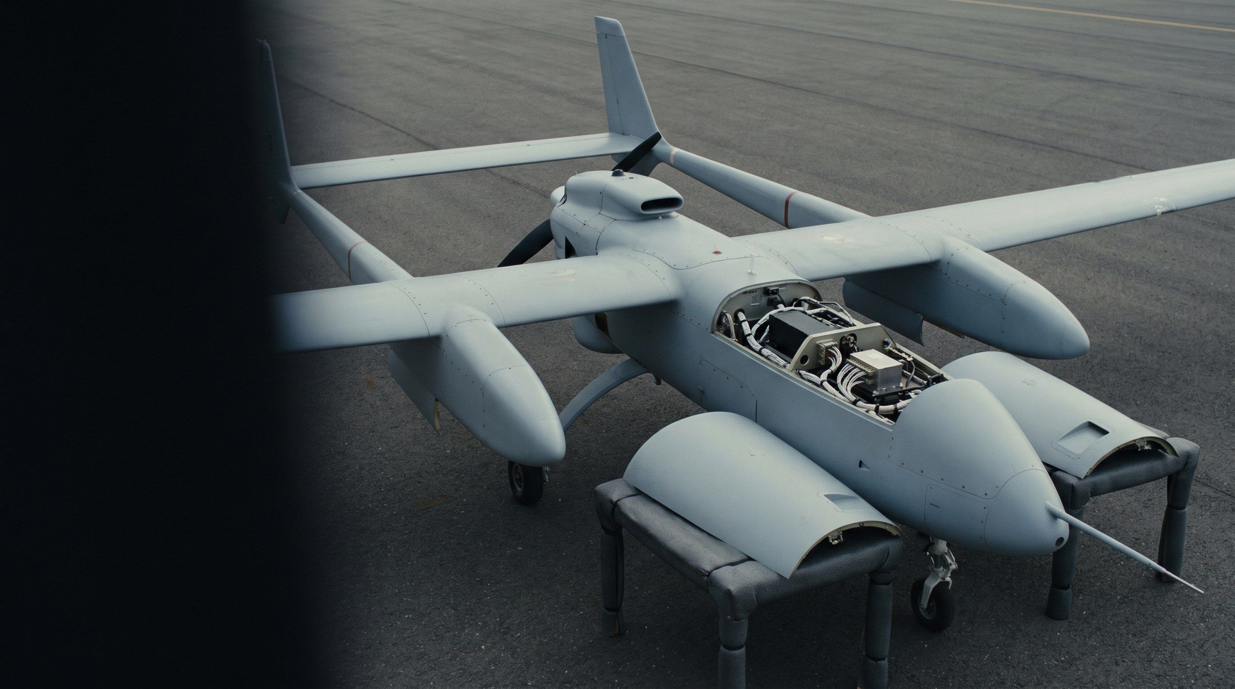 Illustrative generic unmanned aircraft in a hangar with avionics bays open